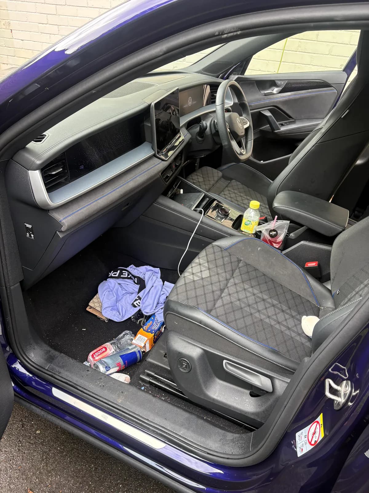 Blue SUV front seat and footwell before interior cleaning